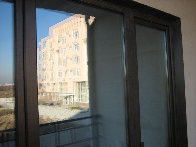 Вид ламинированного пвх нащельника на остекление балконного блока 